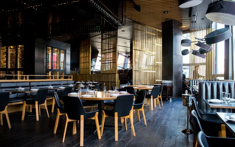 Bistro iç mekanında sıcak aydınlatma ve restoran masa düzeni